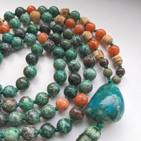 rohelised, sinised, oranzid ümmargused pärlid kristallid kaelakees malas. Roheline tutt. heledal taustal