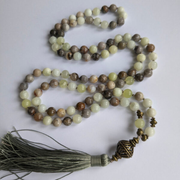 kollased, rohelised, pruunid, ümmargused kristallid pärlid. Spirituaalsed Mala palvehelmed kaelakee. Hall tutt. Heledal taustal