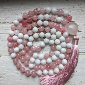 roosad ja valged ümmargused kristallid pärlid. Roosa süda. Mala palvehelmed kaelakee. Roosa siidi tutt. Heledal taustal