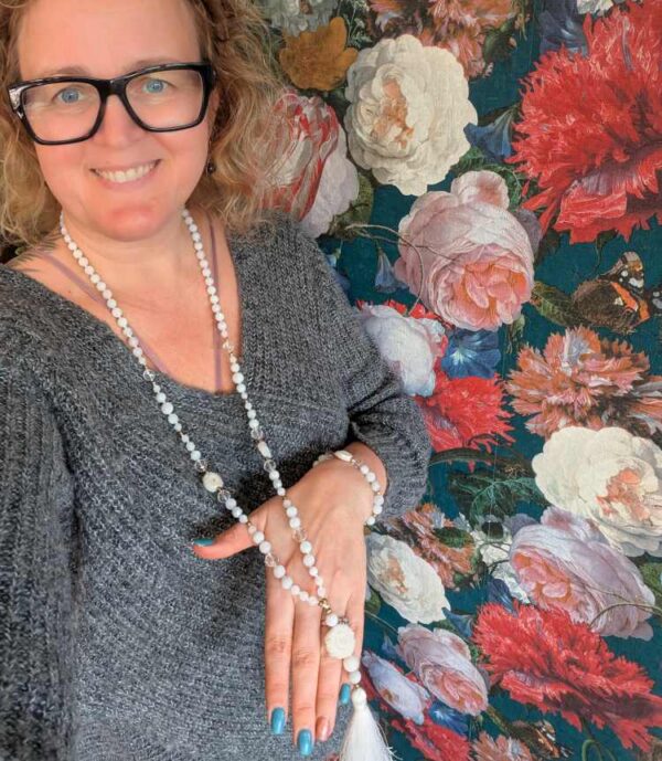 Käsitööna valminud unikaalne kristallidest kroontsakra toetuse mala palvehelmed naistele. Valge Kuukivi ja Mäekristalli kristallid pärlid. Ahhaat Guru ehk õpetaja kivi. 108 pärliga spirituaalne kaelakee ehk Mala palvehelmed. Siidiniit. Valge tutt. Heledal taustal.