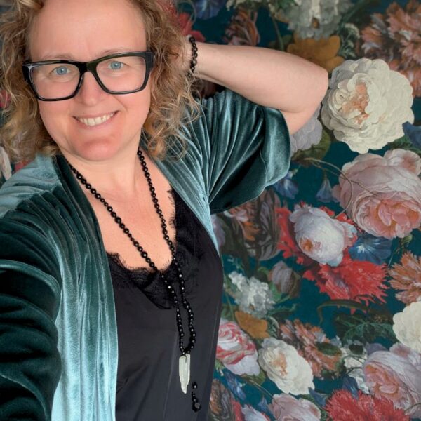 Naeratav naine kannab mustadest helmestest valmistatud käsitöö Mala palvehelmeid, millel on Seleniidi GURU ripats, rohelise sametise kimono ja lillelise tapeedi taustaga.