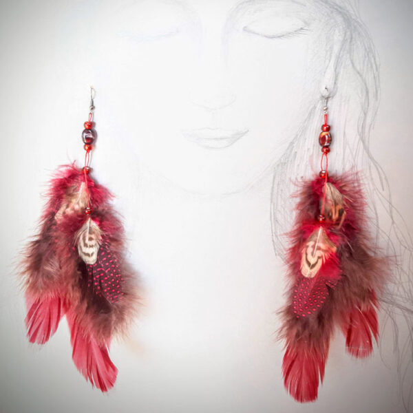 Punaste ja pruunikate sulgedega kõrvarõngad paberile joonistatud naise kõrvade küljes