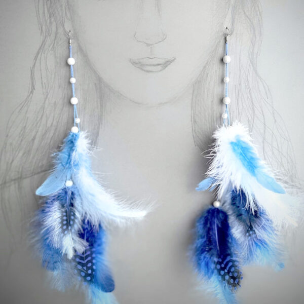 Valgete ja siniste sulgedega kõrvarõngad paberile joonistatud naise kõrvade küljes