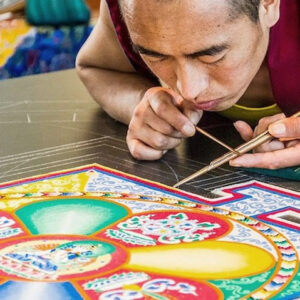 tiibeti munk põlvili maas kirjut liivamandalat loomas
