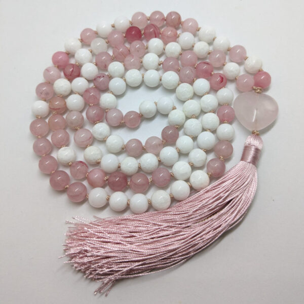 roosad ja valged ümmargused kristallid pärlid. Roosa süda. Mala palvehelmed kaelakee. Roosa siidi tutt. Heledal taustal