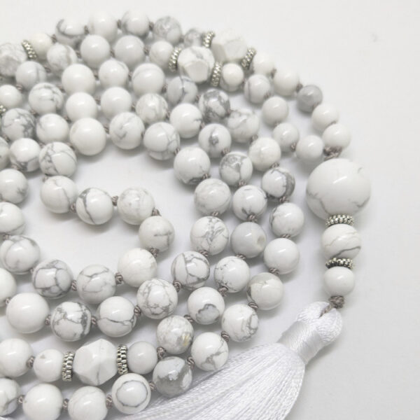 valged ümmargused kristallid pärlid. Valge Hauliit Guru ehk õpetaja kivi. 108 pärliga Mala palvehelmed kaelakee. Valge siidi tutt. Heledal taustal