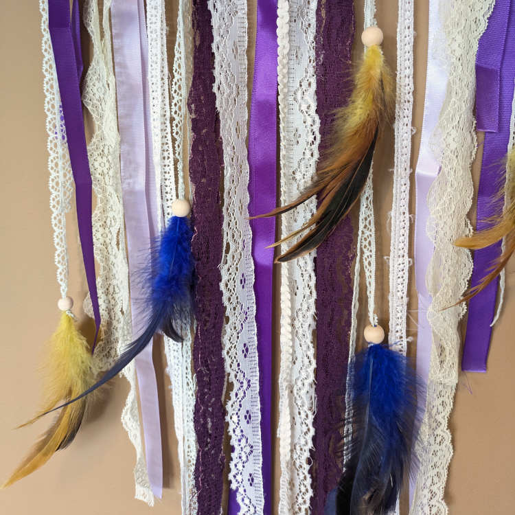 Boho stiilis lillades ja kuldsetes toonides unenäopüüdja pitsi ja sulgedega. Mandala ILU käsitöö