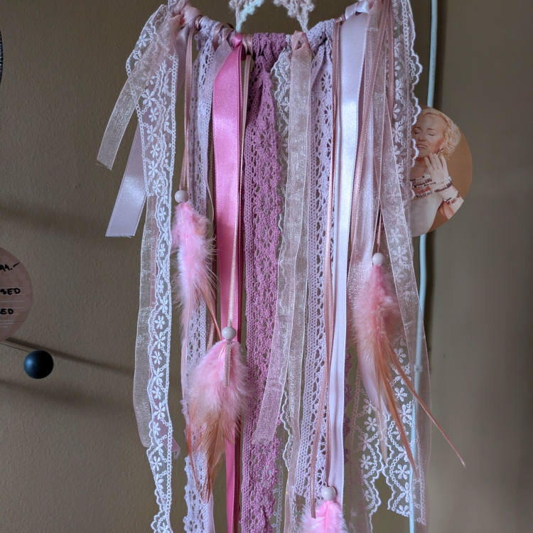 Mandala ILU Unenäopüüdja Roosa õndsus pikad roosad paelad ja suled seinal rippumas